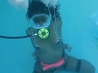 Tanned babe ties herself up underwater with a mask on